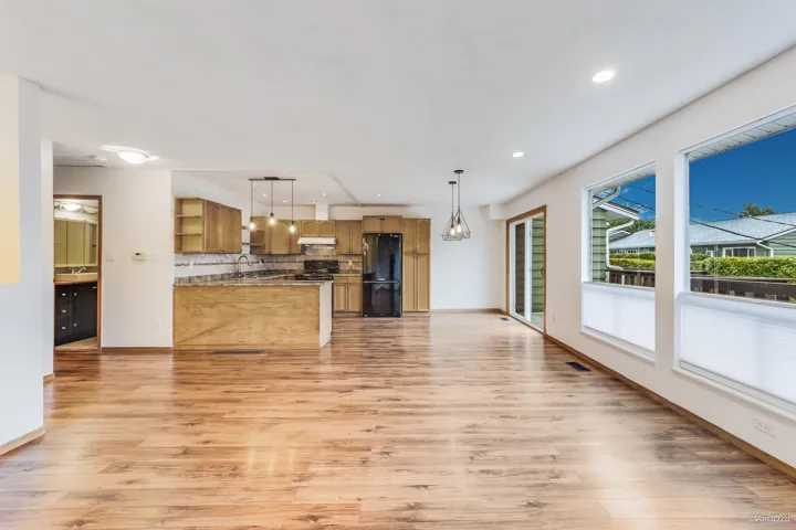 Kitchen with freestanding refrigerator, open shelves, under cabinet range hood, light wood-style floors, and decorative backsplash