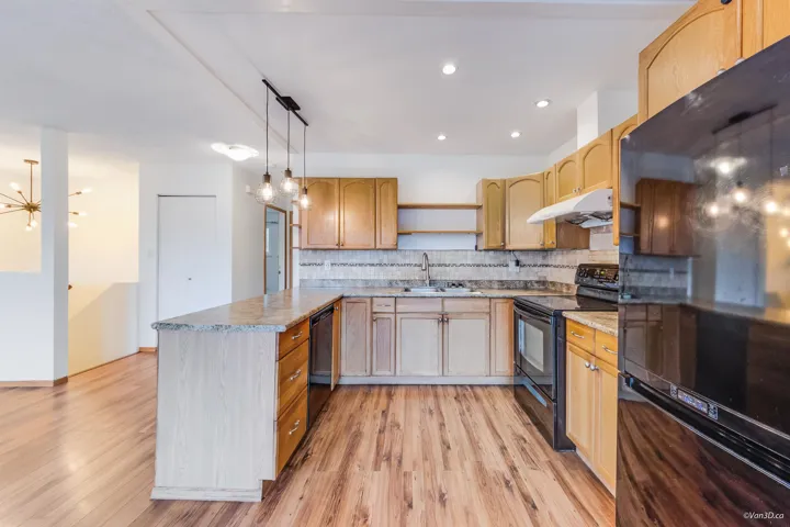 Kitchen featuring open shelves, a sink, a peninsula, under cabinet range hood, and black appliances