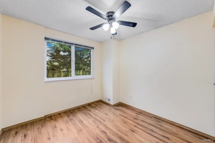 Empty room featuring a textured ceiling, light wood finished floors, a ceiling fan, and visible vents