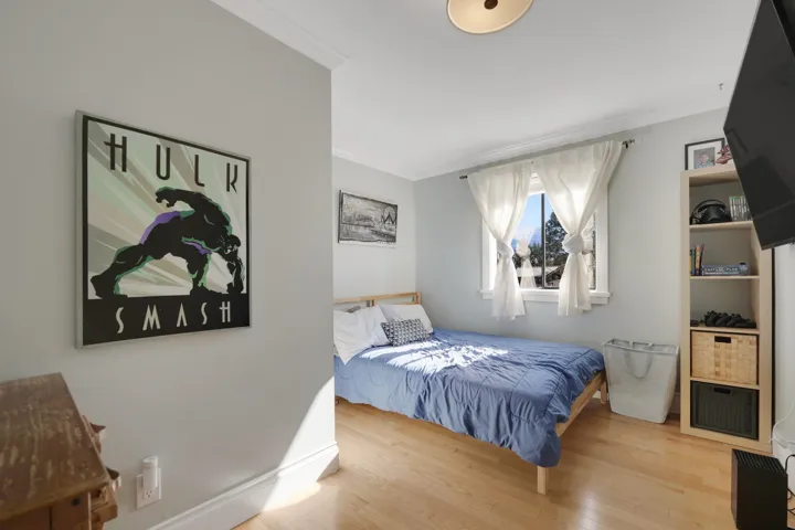 Bedroom with wood finished floors and crown molding