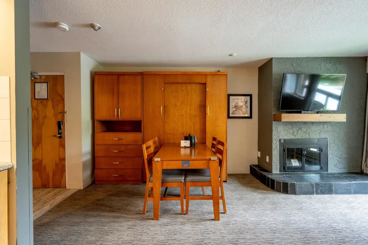 Carpeted dining room featuring a textured ceiling and a tiled fireplace