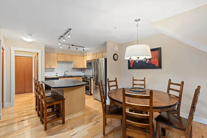 Dining area with light wood-style flooring and rail lighting