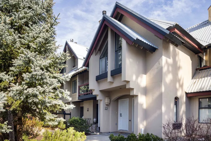 View of side of home with stucco siding and a metal roof
