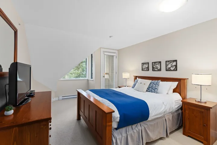 Bedroom with carpet floors, a baseboard heating unit, and a desk