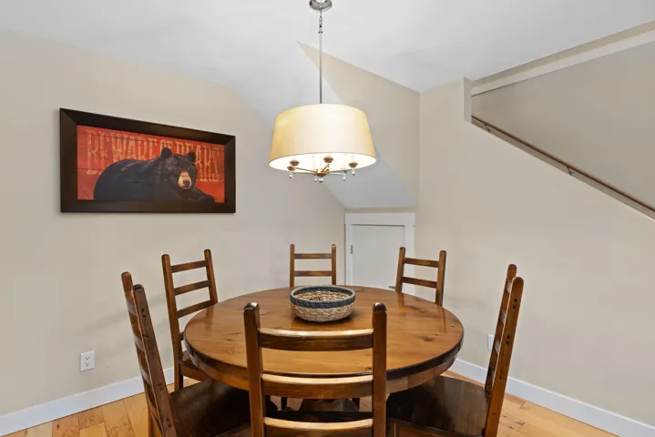 Dining room featuring light wood-type flooring and vaulted ceiling