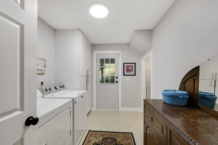Laundry area featuring washing machine and clothes dryer, light flooring, and cabinet space