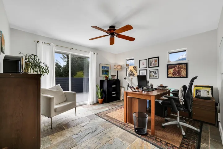 Office space featuring stone tile flooring and a ceiling fan