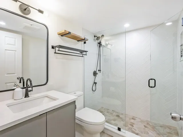 Bathroom with a shower stall, vanity, and recessed lighting