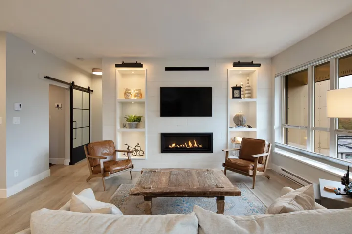 Living area featuring baseboards, a fireplace, a barn door, and wood finished floors