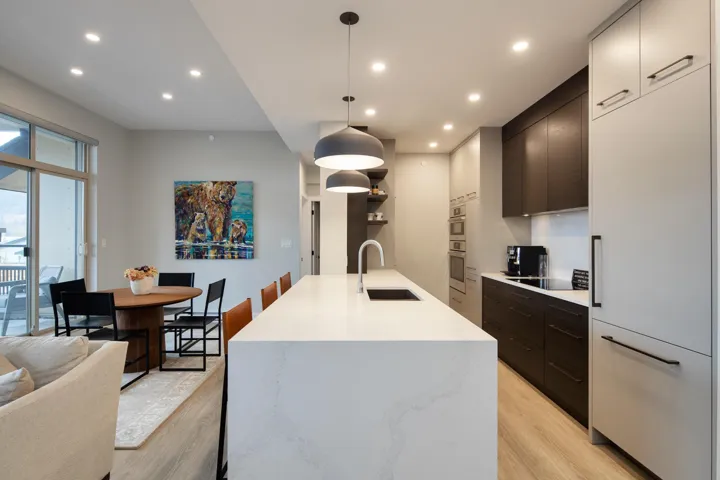 Kitchen featuring light countertops, a sink, modern cabinets, and light wood finished floors