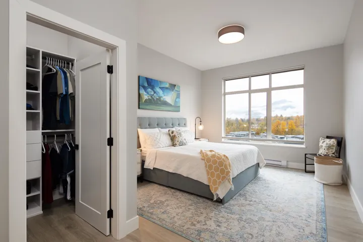 Bedroom featuring a baseboard radiator, a closet, wood finished floors, and a spacious closet