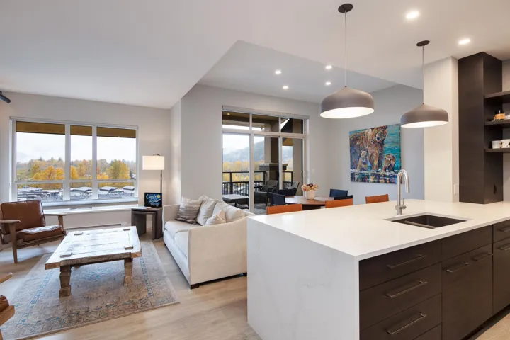 Kitchen featuring open floor plan, light countertops, a sink, light wood finished floors, and modern cabinets