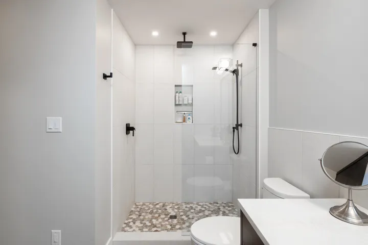 Full bathroom with a tile shower, recessed lighting, toilet, and vanity