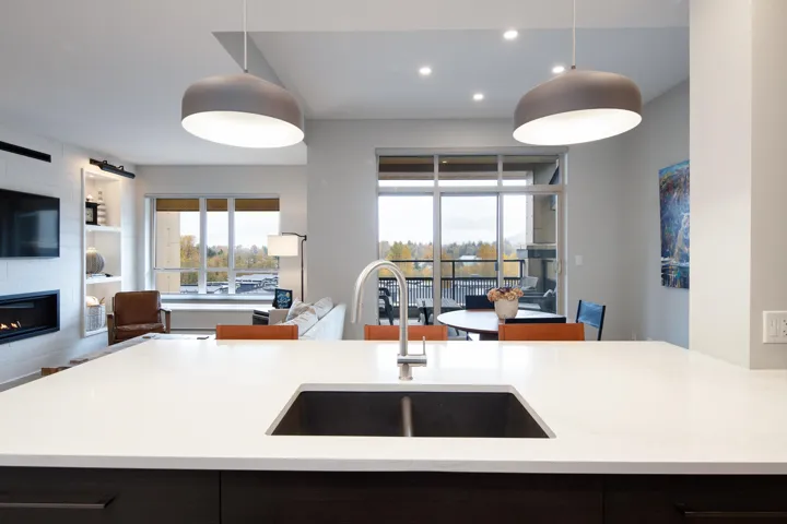 Kitchen with open floor plan, a large fireplace, a sink, and pendant lighting