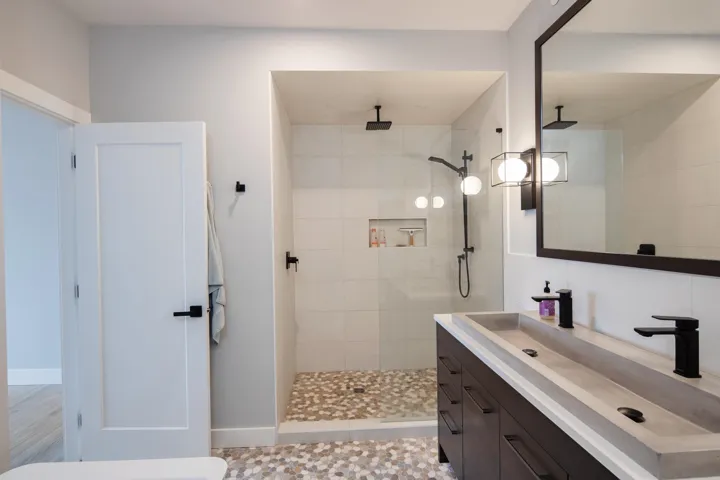 Full bath featuring vanity and tiled shower
