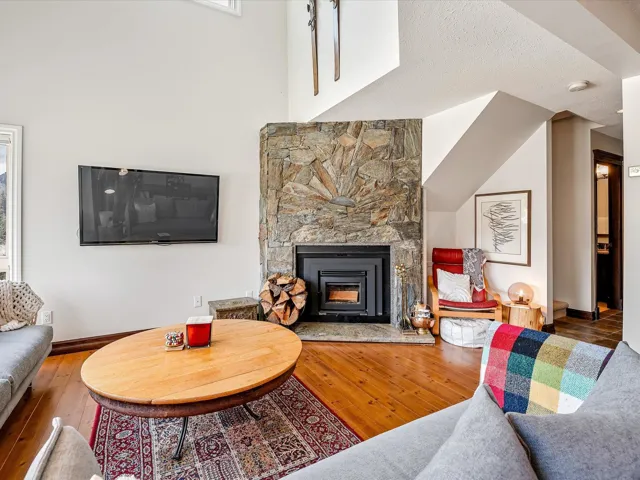 Living room with baseboards, a fireplace, and hardwood / wood-style flooring