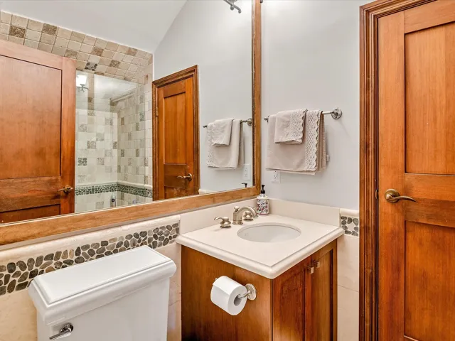 Bathroom with lofted ceiling, toilet, and vanity