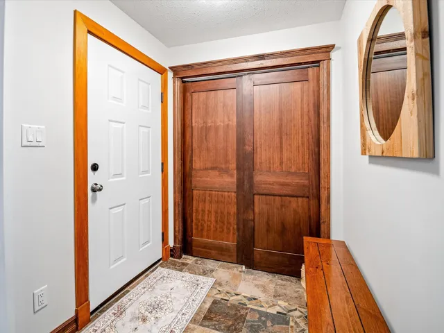 Foyer entrance featuring stone finish floor and a textured ceiling