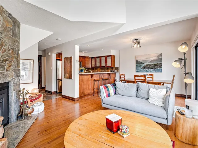 Living area with light wood-style flooring, baseboards, a fireplace, and a textured ceiling