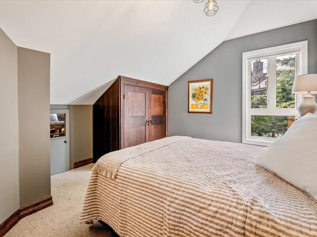 Bedroom featuring baseboards, carpet floors, and vaulted ceiling