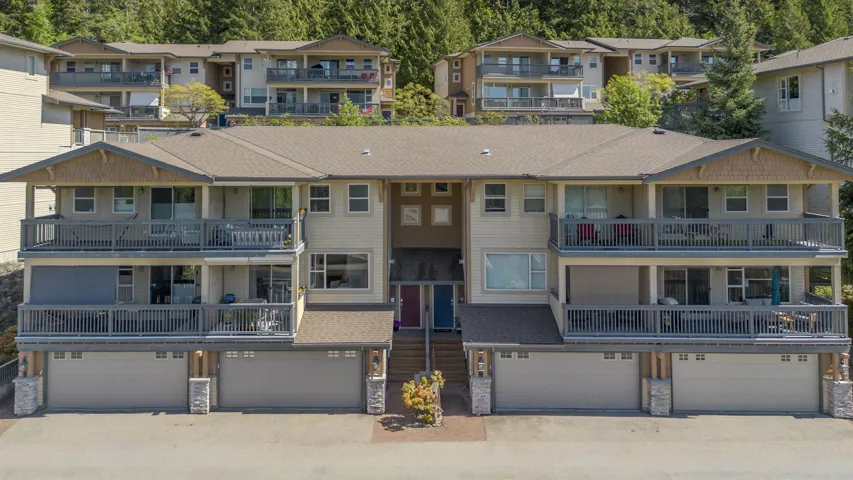 Multi-level residential building featuring private garages, individual balconies, and multiple windows