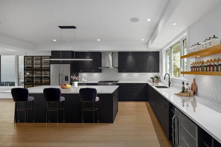 Kitchen featuring dark cabinetry, a center island, light wood-type flooring, a breakfast bar, and decorative backsplash