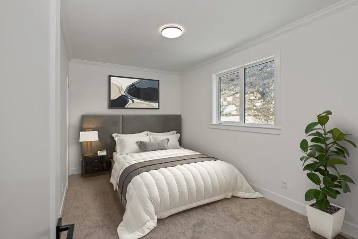 Carpeted bedroom with ornamental molding and baseboards