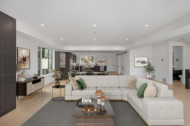 Living area featuring light wood-style floors, recessed lighting, a barn door, and a raised ceiling