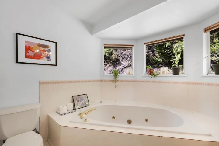 Bathroom featuring toilet and a tub with jets