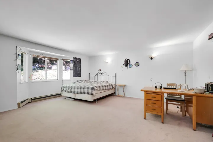 Bedroom featuring a baseboard heating unit and light carpet