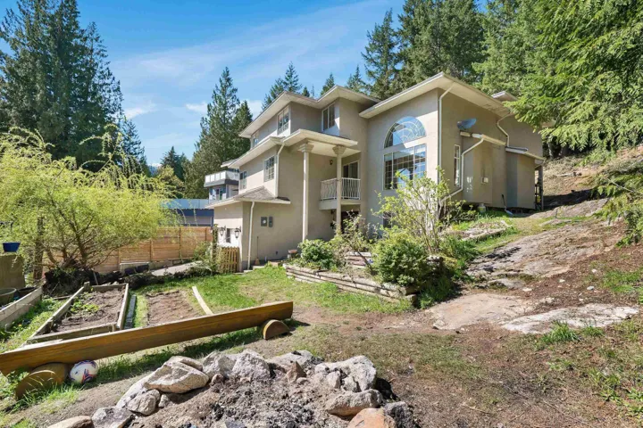 Back of property with a garden, a balcony, and stucco siding
