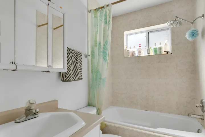 Full bathroom featuring toilet, vanity, and tiled shower / bath