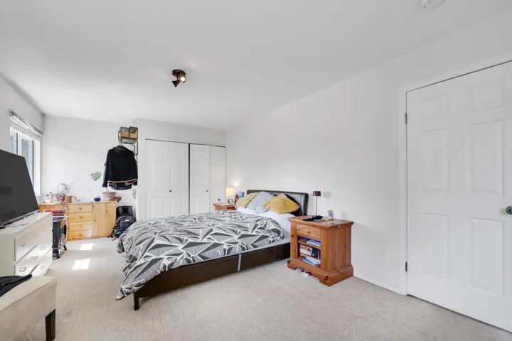 Carpeted bedroom with a closet