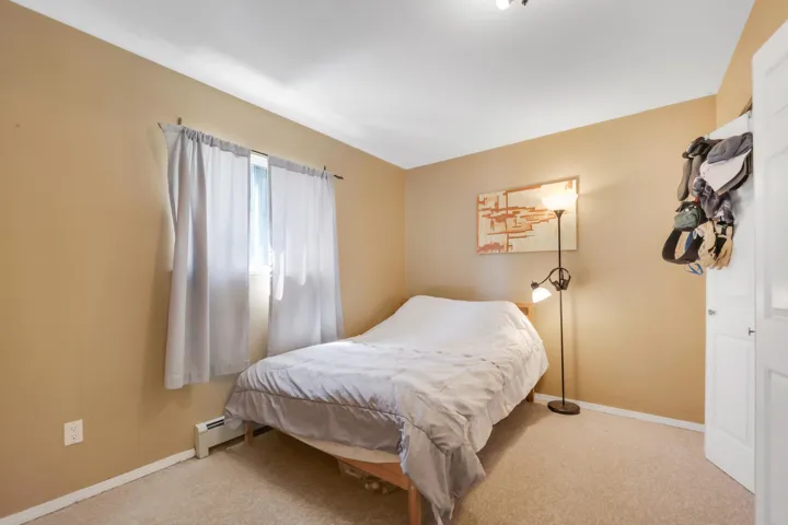 Bedroom with a baseboard radiator, baseboards, and carpet flooring