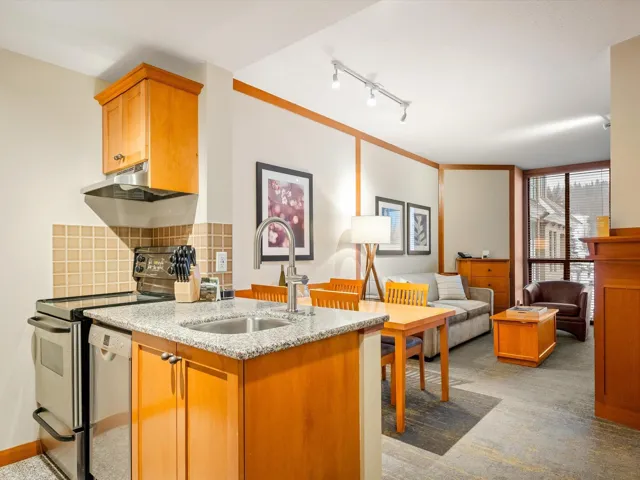 Kitchen featuring a sink, stainless steel dishwasher, range with electric stovetop, decorative backsplash, and light stone countertops