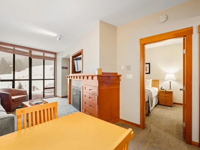 Dining area with a glass covered fireplace, floor to ceiling windows, baseboards, and carpet floors