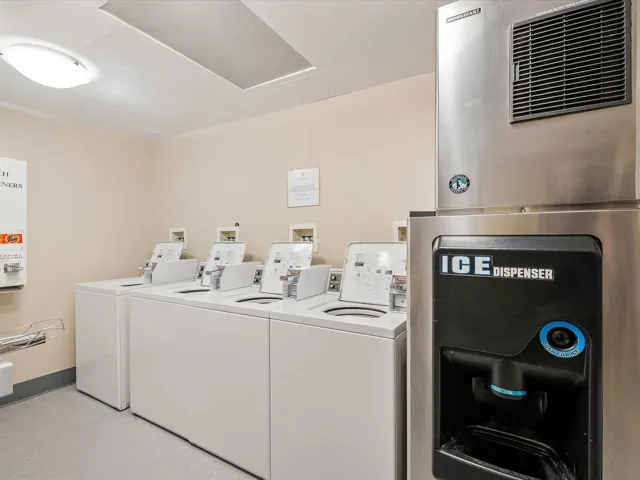 Common laundry area with washer and clothes dryer and baseboards