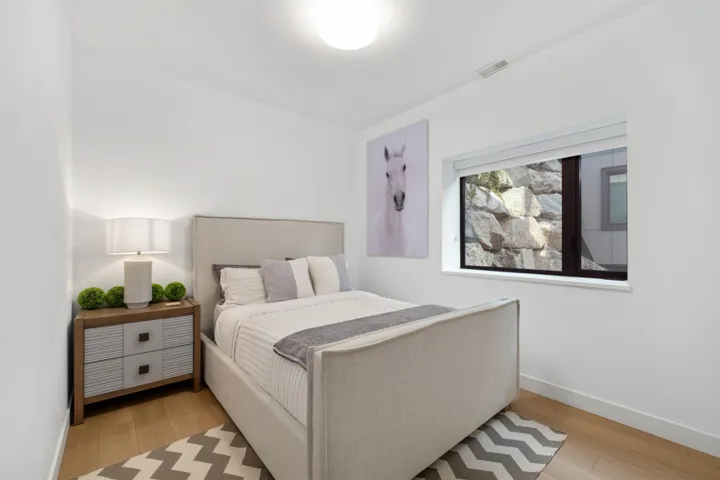Hardwood-style flooring, recessed overhead lighting, and a single window with a privacy roller shade