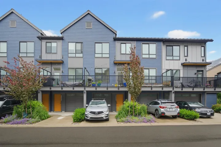 Contemporary townhome exterior featuring blue siding and dark gray architectural panels