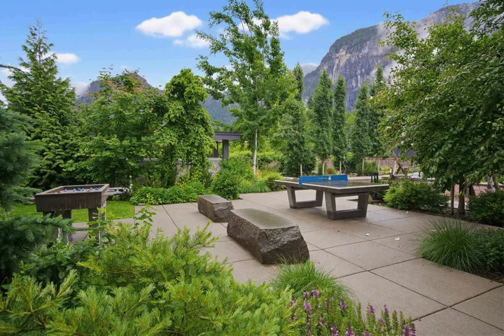 Expansive patio space featuring a built-in ping pong table, stone benches, and a built-in BBQ station