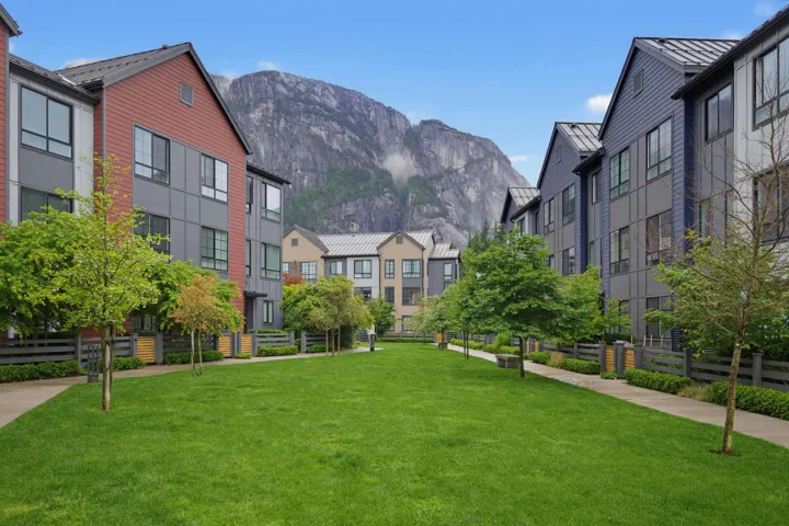 Modern townhome community featuring diverse siding materials, pitched roofs, and private balconies