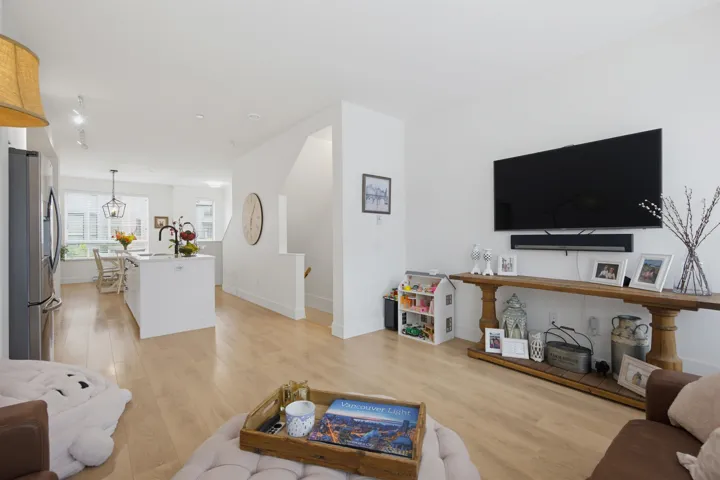 Bright living area featuring wood-finish flooring, white walls, and abundant natural light from multiple windows