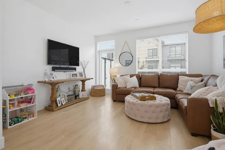 Bright living space featuring wood-finish flooring, white walls, and recessed lighting