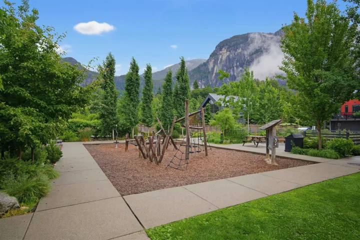 Recreational area featuring a natural wood play structure on a bark mulch surface