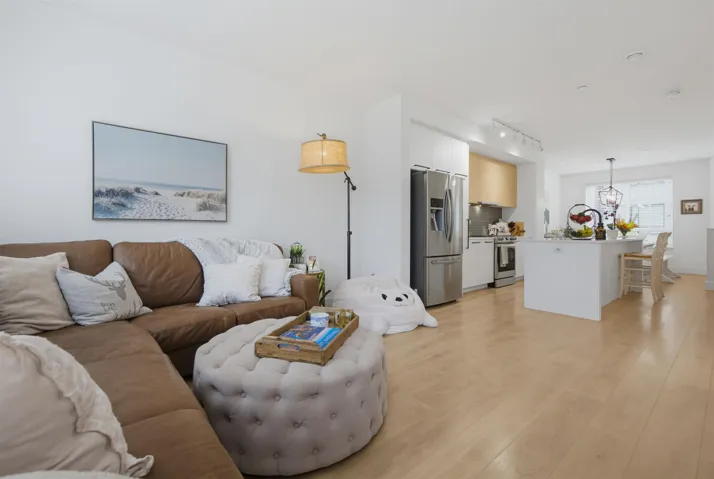 Open-concept living space featuring light wood-finish flooring, white walls, and recessed lighting