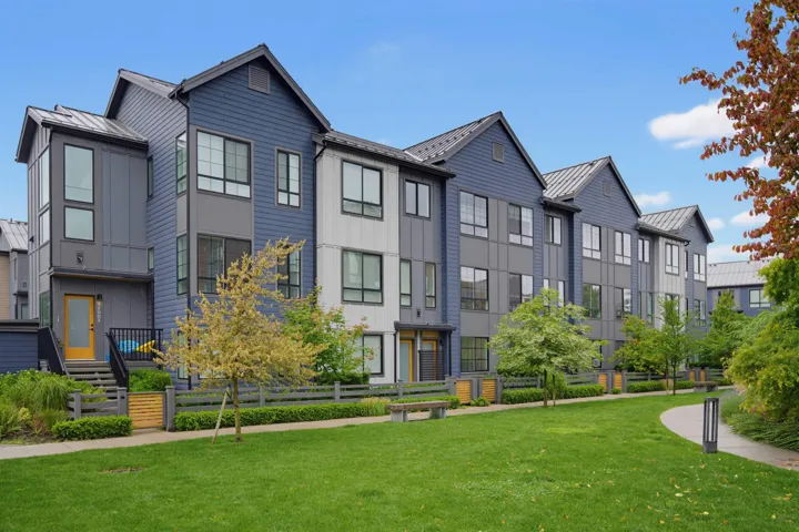 Central green space bordered by contemporary townhomes and a mountainous backdrop