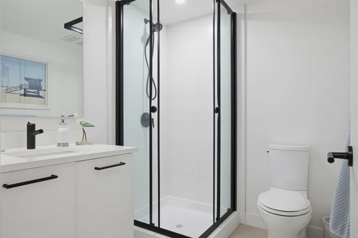 Dedicated laundry alcove with a stacked washer and dryer, featuring white appliances and utility connections