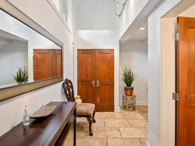 Foyer entrance featuring baseboards, recessed lighting, stone tile flooring, and a towering ceiling