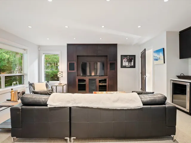 Living area with beverage cooler, light carpet, and recessed lighting