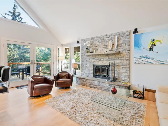 Living area featuring wood finished floors, french doors, plenty of natural light, and high vaulted ceiling